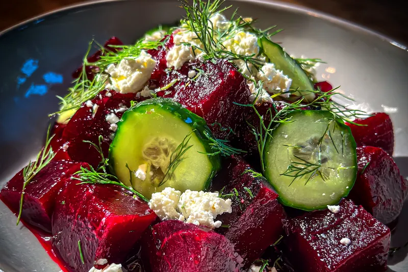 An array of fresh ingredients for Vibrant Beet and Feta Salad, including beets, feta, and greens.
